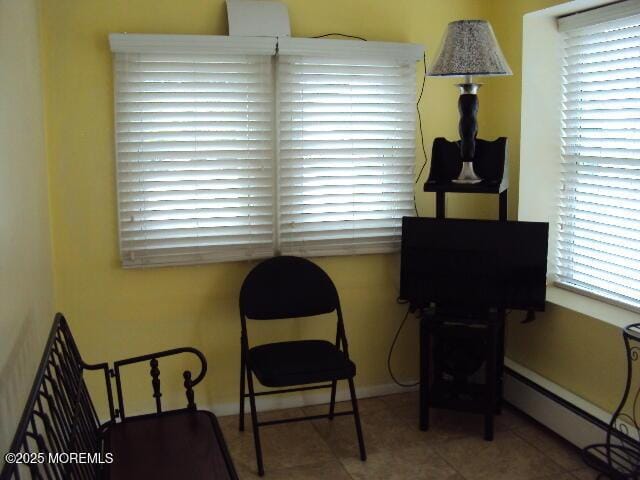 living area featuring tile patterned floors and a baseboard heating unit