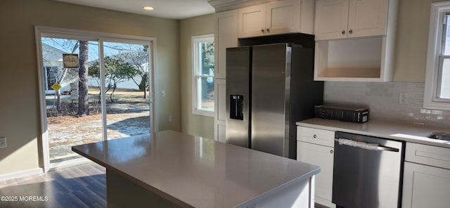 kitchen with white cabinetry, light hardwood / wood-style flooring, stainless steel appliances, and tasteful backsplash