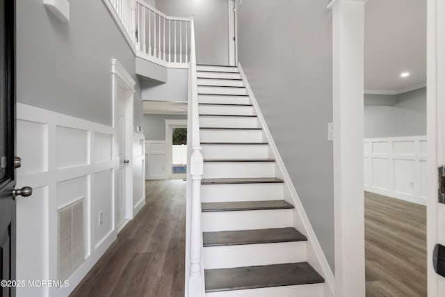 stairs featuring hardwood / wood-style floors and crown molding