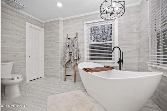 bathroom featuring toilet, tile walls, a chandelier, crown molding, and a washtub