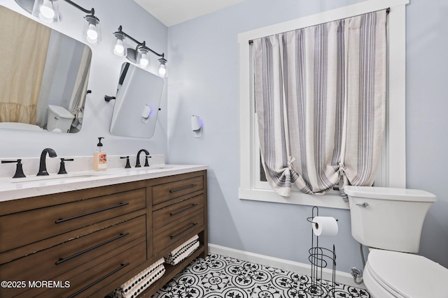 bathroom with toilet, tile patterned floors, and vanity