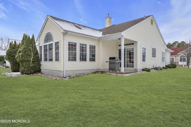 rear view of property featuring a lawn