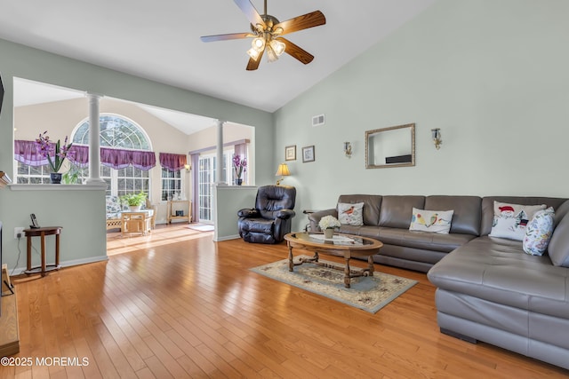 living room featuring ornate columns, vaulted ceiling, ceiling fan, and light hardwood / wood-style flooring