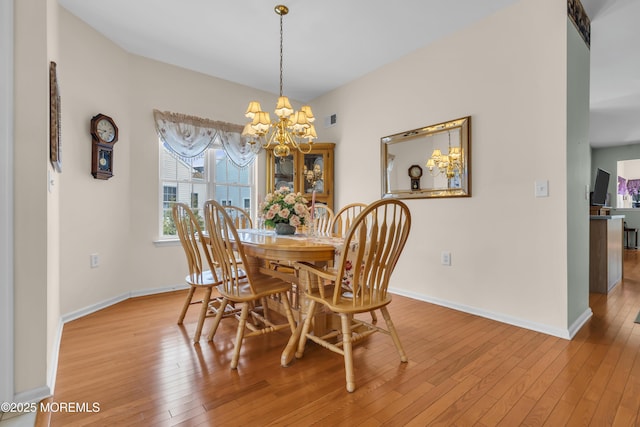 dining area featuring light hardwood / wood-style flooring and a notable chandelier