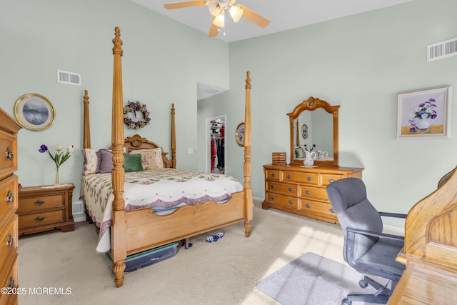 bedroom with a walk in closet, high vaulted ceiling, light carpet, a closet, and ceiling fan