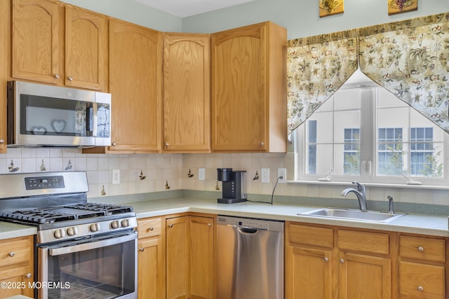 kitchen with sink, decorative backsplash, and appliances with stainless steel finishes