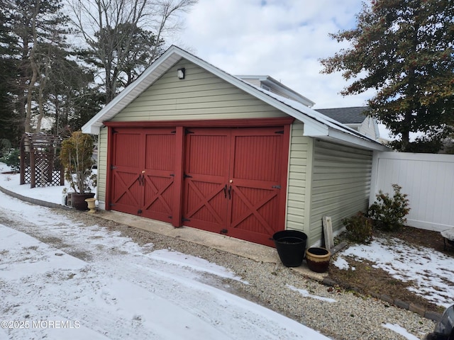 snow covered structure featuring a garage