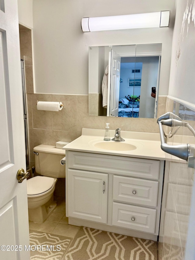 bathroom featuring vanity, tile walls, tile patterned floors, and toilet