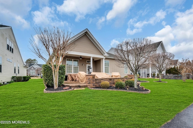 view of front of property featuring a front lawn, ceiling fan, and a patio