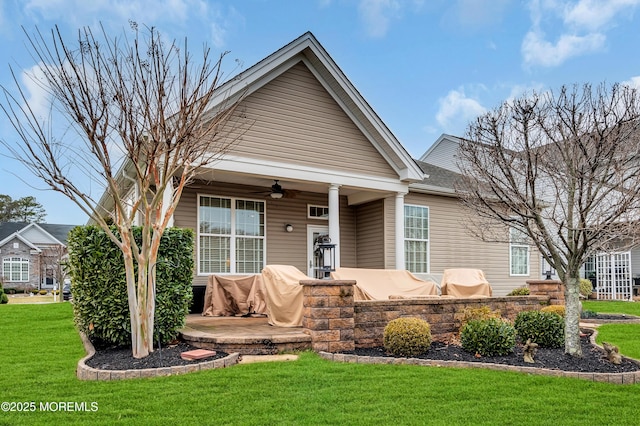 view of front of property with a front lawn, a patio area, and ceiling fan