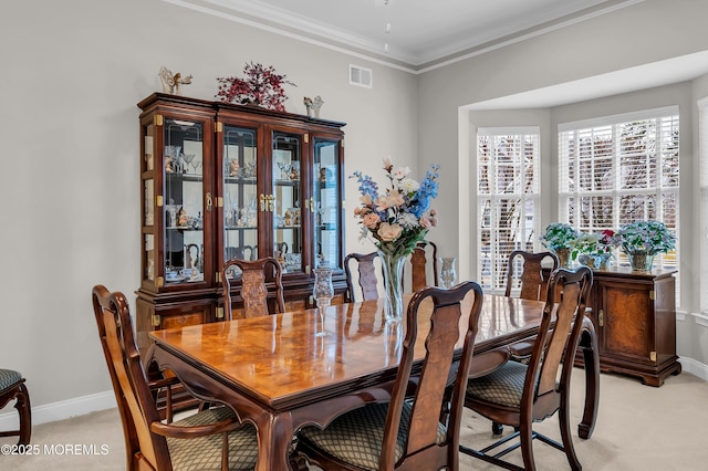 dining area with light carpet and ornamental molding