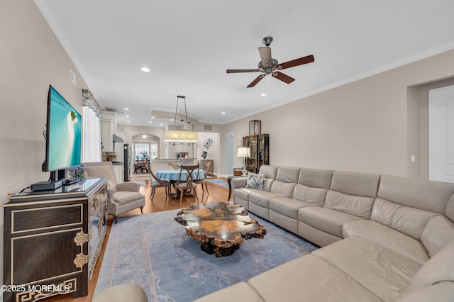 living room with ceiling fan, crown molding, and hardwood / wood-style flooring