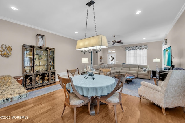 dining area featuring light wood-type flooring and crown molding