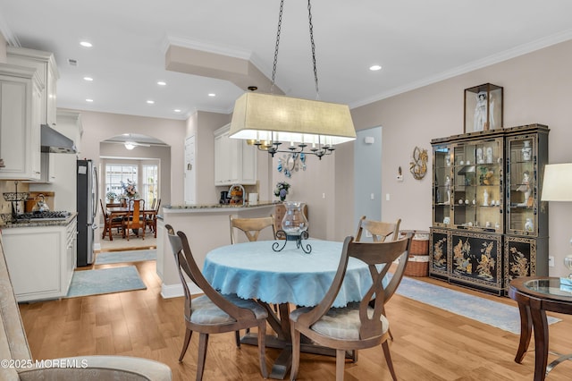 dining room featuring ceiling fan, sink, crown molding, and light hardwood / wood-style floors