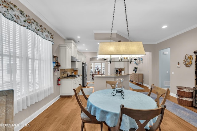 dining space featuring light hardwood / wood-style flooring and crown molding