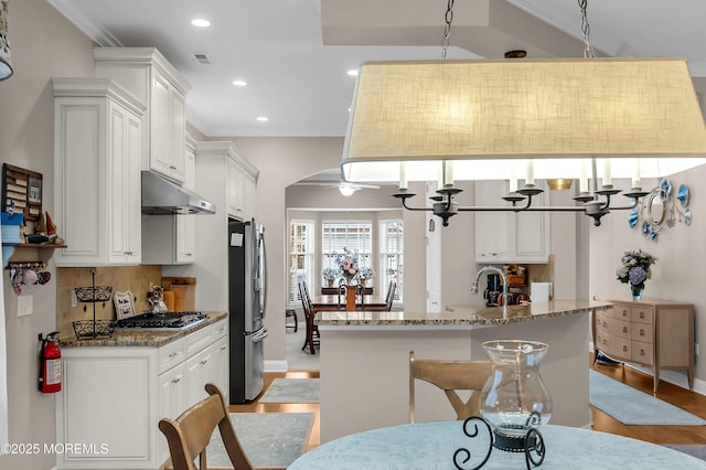 kitchen featuring stone countertops, white cabinetry, appliances with stainless steel finishes, and tasteful backsplash