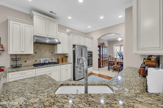 kitchen featuring appliances with stainless steel finishes, white cabinetry, and light stone counters