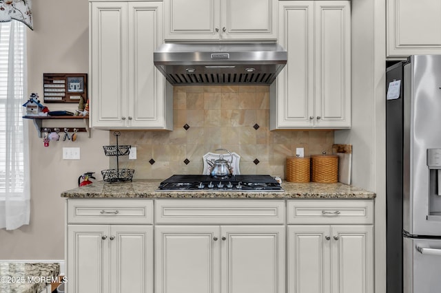 kitchen featuring range hood, stainless steel appliances, backsplash, and white cabinetry