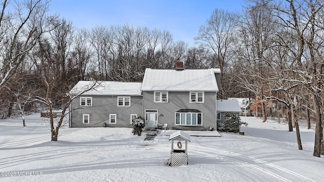 view of snow covered back of property