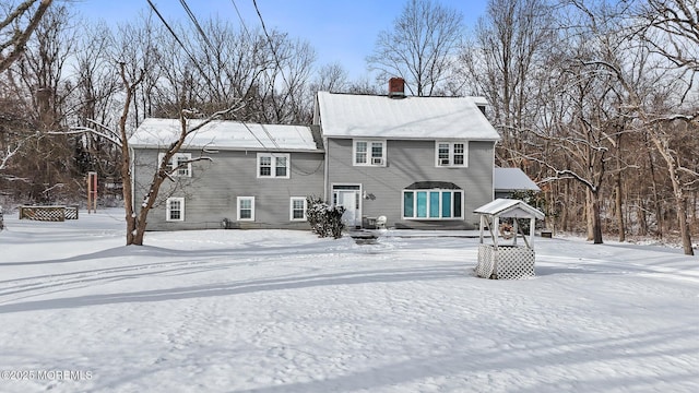 view of snow covered rear of property