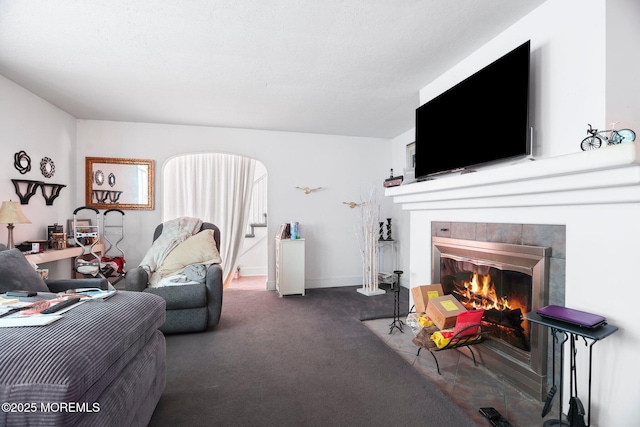 carpeted living room featuring a tile fireplace