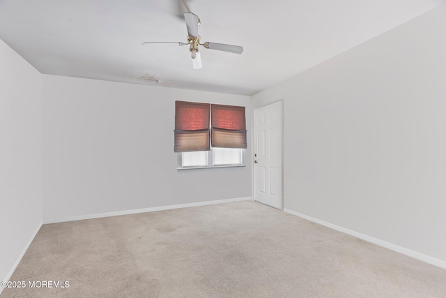 empty room with ceiling fan and light carpet