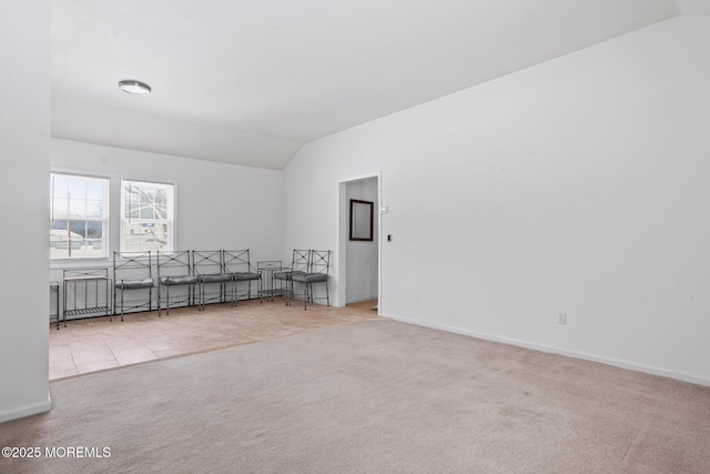 carpeted empty room featuring lofted ceiling