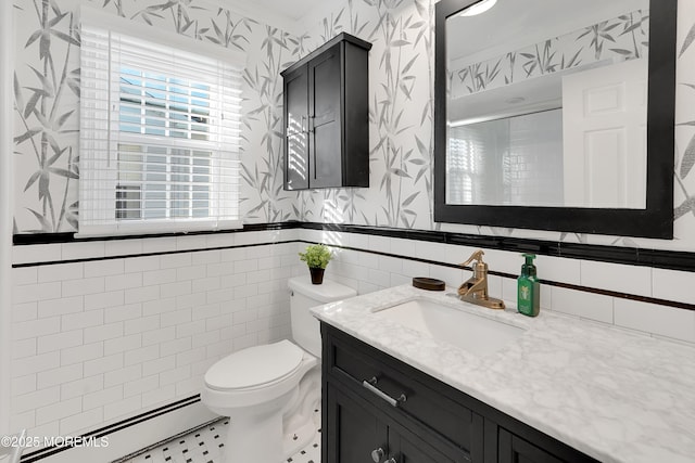 bathroom with a baseboard radiator, tile walls, vanity, toilet, and a shower with door