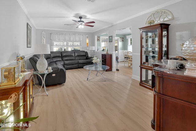 living room with crown molding, ceiling fan, and light hardwood / wood-style flooring