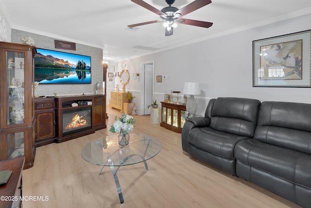 living room featuring crown molding, ceiling fan, and light hardwood / wood-style flooring