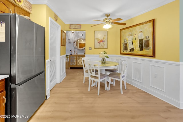 dining room featuring light hardwood / wood-style flooring, ornamental molding, and ceiling fan