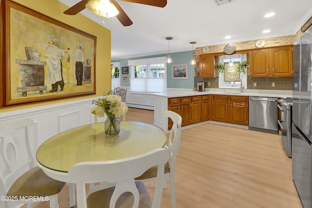 kitchen featuring appliances with stainless steel finishes, sink, hanging light fixtures, kitchen peninsula, and a healthy amount of sunlight