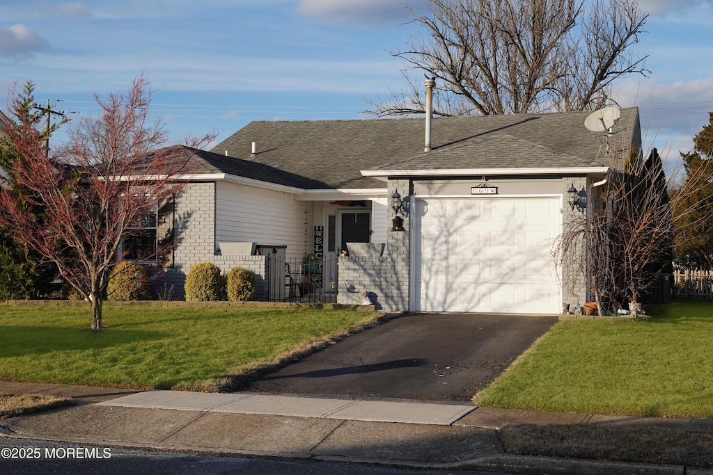 single story home with a garage and a front lawn