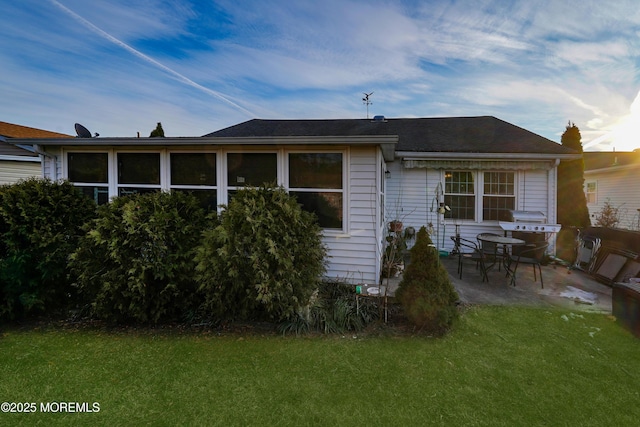 back of house featuring a lawn and a patio area