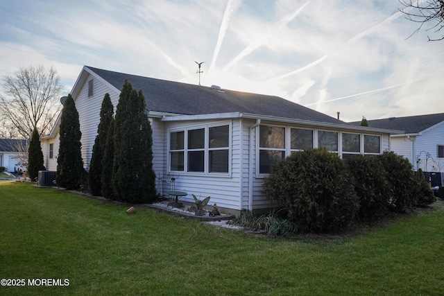 view of property exterior with a yard and central AC