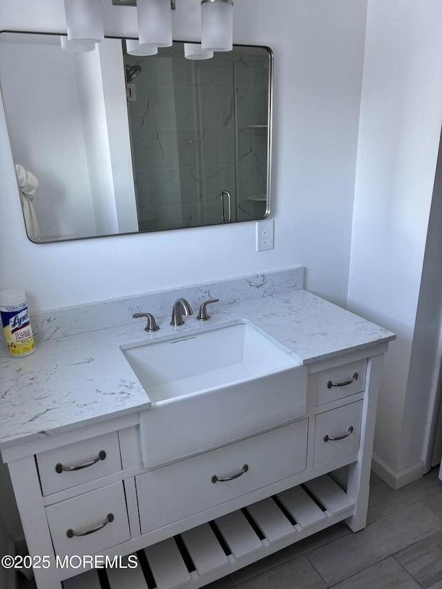 bathroom with a shower with door and vanity