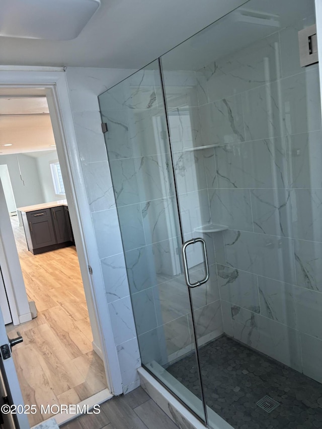 bathroom with hardwood / wood-style floors and an enclosed shower