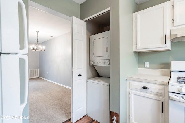 laundry area with light colored carpet, stacked washer / dryer, and a chandelier