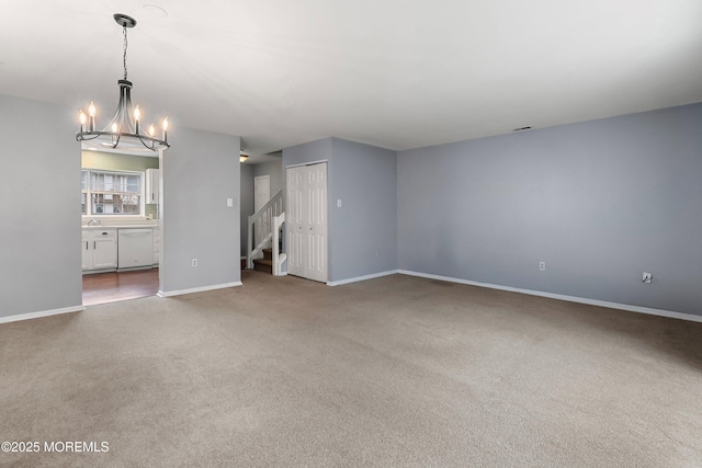 unfurnished living room with carpet floors and an inviting chandelier