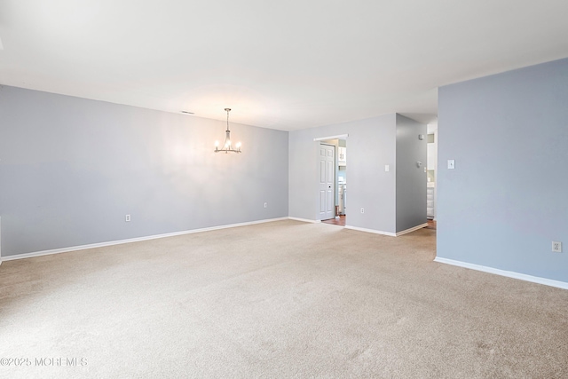 unfurnished room featuring light carpet and an inviting chandelier