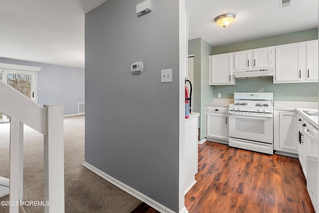 kitchen featuring dark wood-type flooring, white cabinets, and white gas range oven