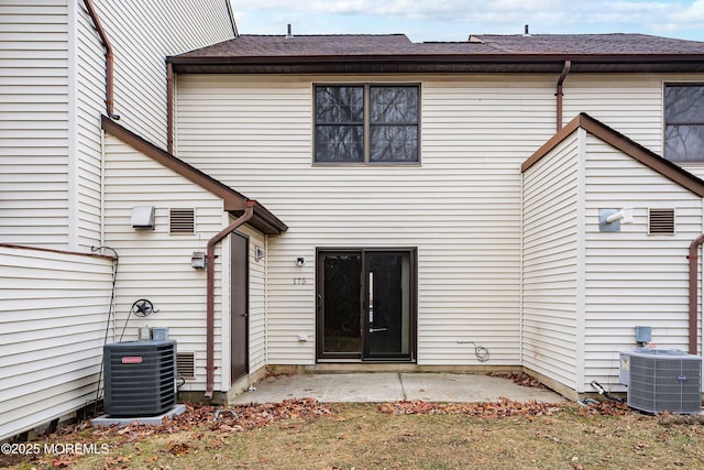 rear view of house with central AC and a patio