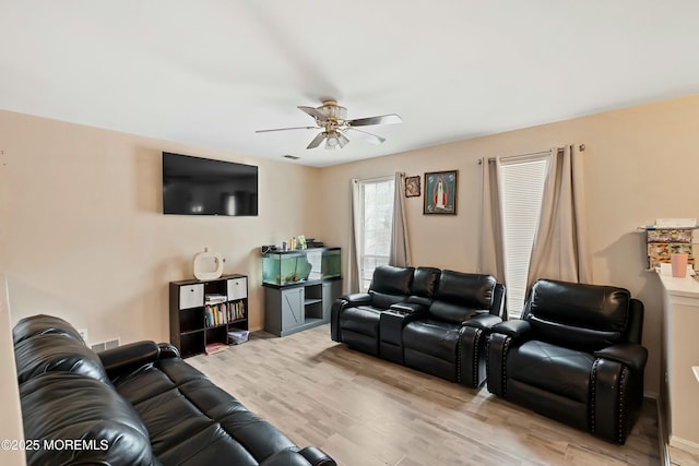 living room featuring ceiling fan and light hardwood / wood-style flooring