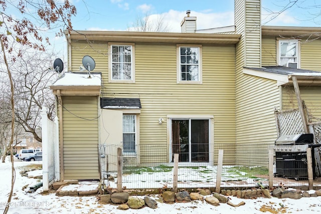 view of snow covered rear of property