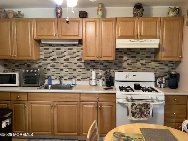 kitchen featuring decorative backsplash, sink, and white appliances