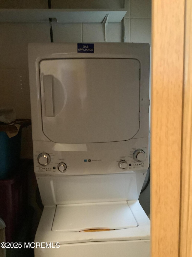 clothes washing area with stacked washer / dryer