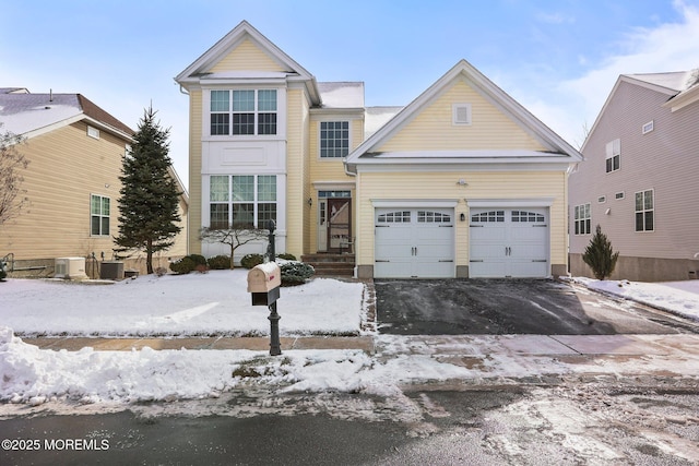 view of property featuring a garage and central air condition unit