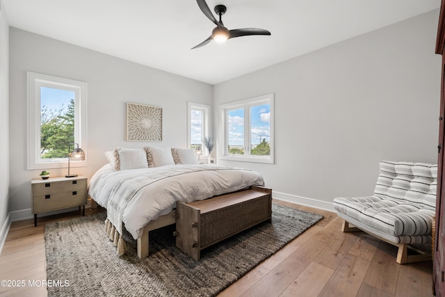 bedroom featuring light wood-type flooring, ceiling fan, and multiple windows