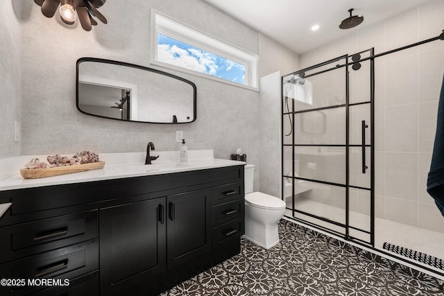 bathroom featuring vanity, toilet, tile patterned floors, and a tile shower