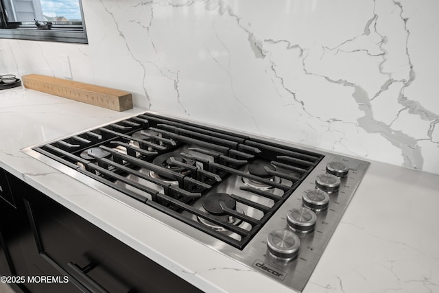 details featuring light stone countertops and stainless steel gas cooktop